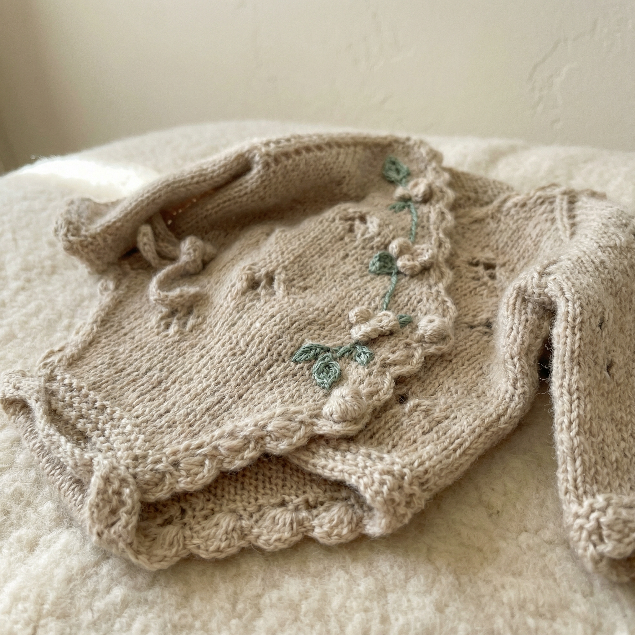 Detail of soft Egyptian cotton texture on a handmade newborn knit romper, a unique piece of luxury knit newborn clothes.