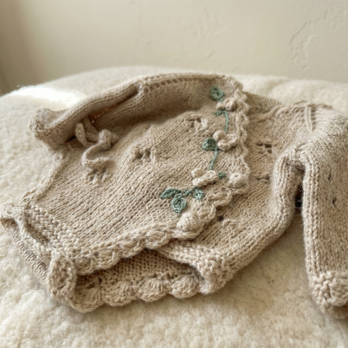 Detail of soft Egyptian cotton texture on a handmade newborn knit romper, a unique piece of luxury knit newborn clothes.