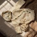 Handmade knit newborn clothes set featuring a beanie, romper, and booties with floral embroidery – the perfect newborn gift made with soft, premium cotton.