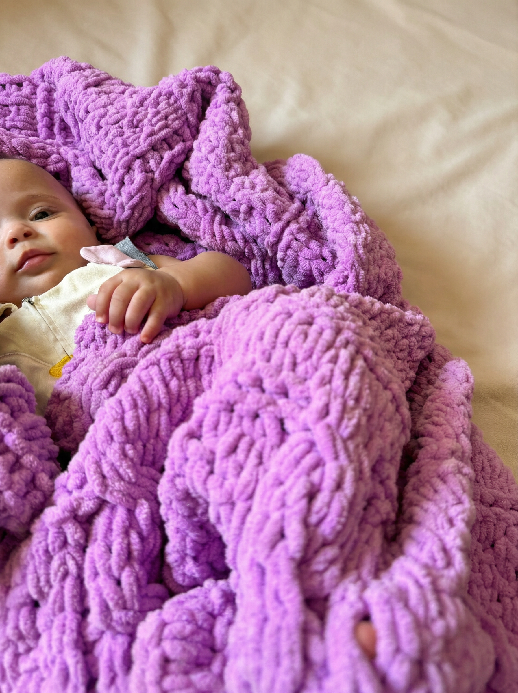 sophyia wrapped in a soft, 100% handmade crochet baby blanket in vibrant purple, providing warmth and comfort – the perfect newborn baby gift.
