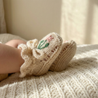 Cream Egyptian cotton newborn knit booties , featuring minimalist hand-embroidered flower design